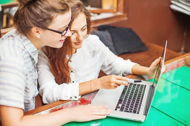 Photo deux jeunes femmes regardant l'ordinateur