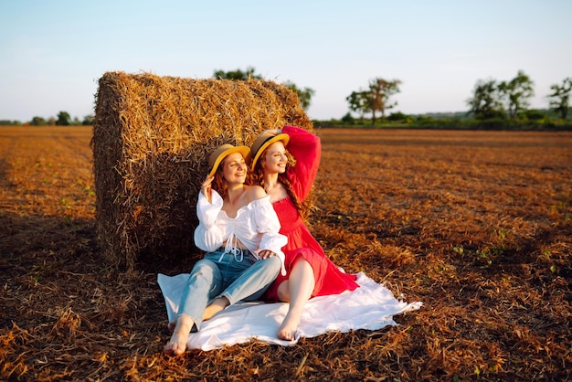 Deux jeunes femmes s'amusant près de botte de foin Concept de mode Concept d'été