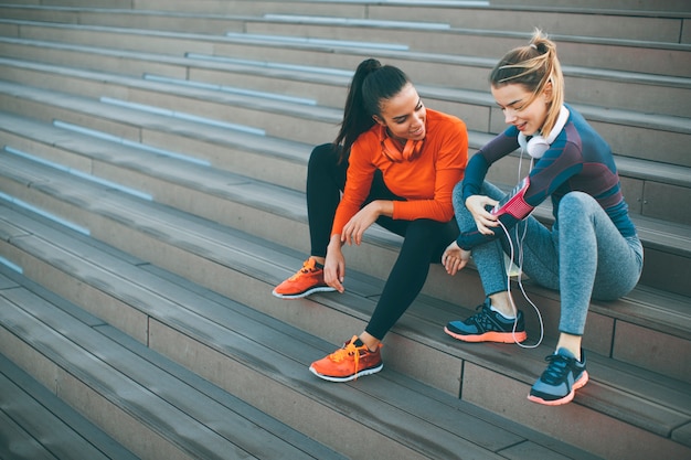 Deux jeunes femmes se reposant après faire du sport en plein air