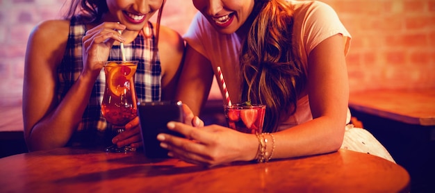 Deux jeunes femmes utilisant un téléphone portable