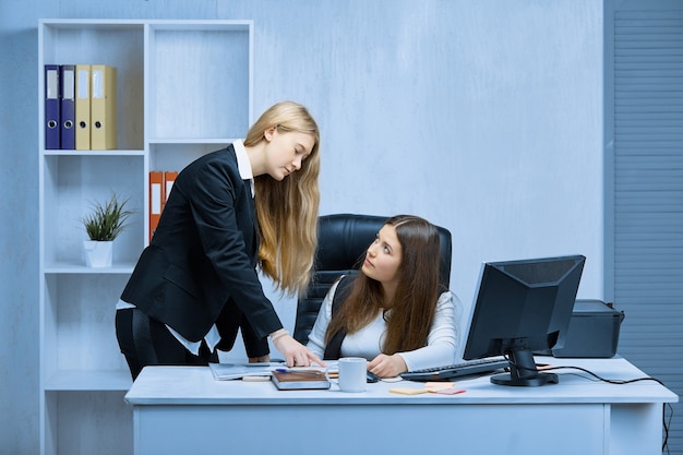 Deux jeunes filles d'affaires travaillent sur un projet commun au bureau