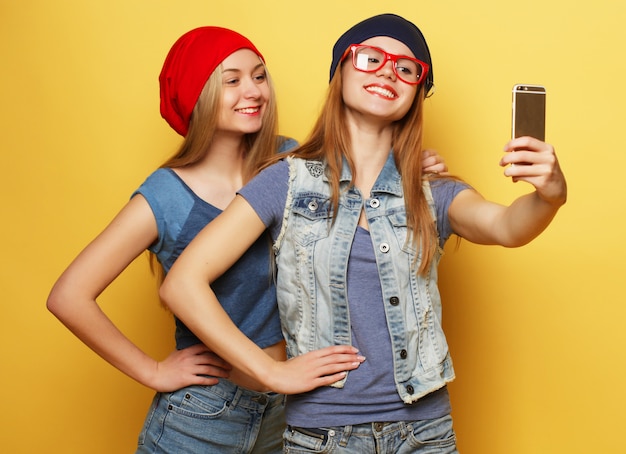 Deux jeunes filles amis hipster prenant selfie