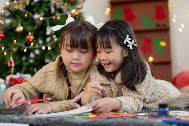 Deux jeunes filles asiatiques heureuses aiment peindre, s'amuser et célébrer Noël ensemble