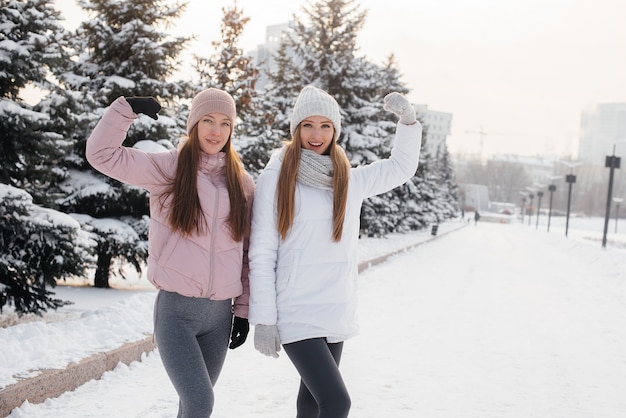 Deux jeunes filles athlétiques marchant et faisant du sport par une journée d'hiver ensoleillée. Un mode de vie sain.