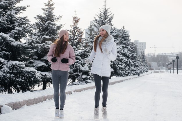 Deux jeunes filles athlétiques qui courent dans le parc par une journée d'hiver ensoleillée. Un mode de vie sain.
