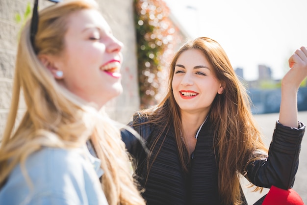 Deux jeunes filles blondes et brunes bavardant