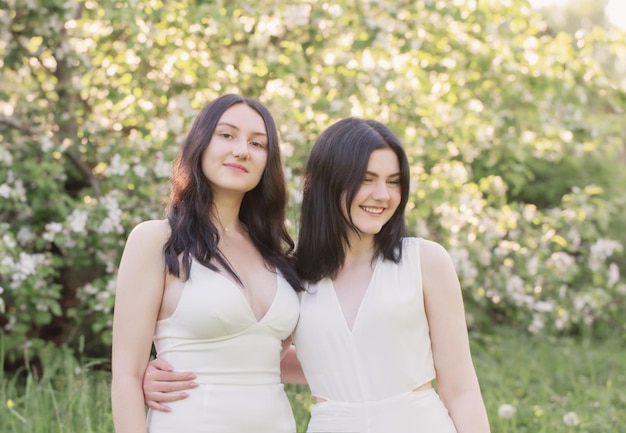 Deux jeunes filles en robe blanche sur fond de pommier à fleurs