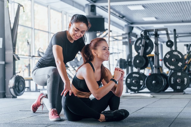 Deux jeunes filles en vêtements de sport sont ensemble dans la salle de sport pendant la journée.