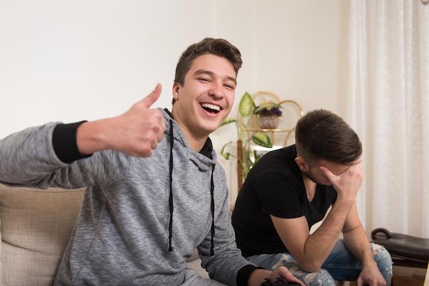 Deux jeunes frères s'amusent ensemble à jouer à des jeux vidéo à la maison