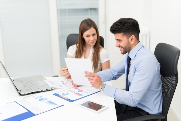 Deux jeunes gens d&#39;affaires au travail dans leur bureau