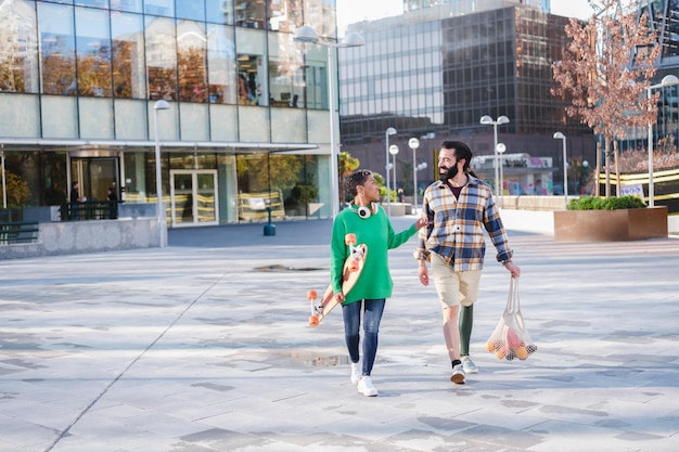 Deux jeunes gens une femme aux cheveux courts et un homme avec une jambe prothétique marchant dans la rue à l'extérieur smiling Concept Lifestyle amis à l'extérieur