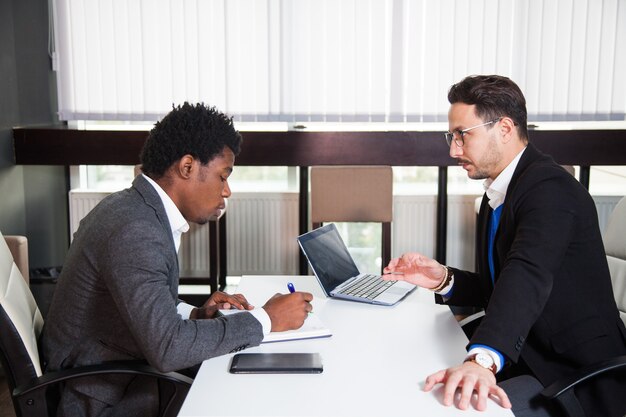 Deux jeunes hommes d'affaires, bureau blanc