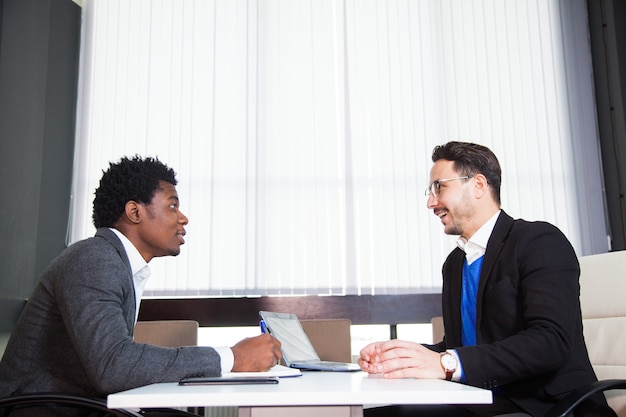 Deux jeunes hommes d'affaires, bureau blanc