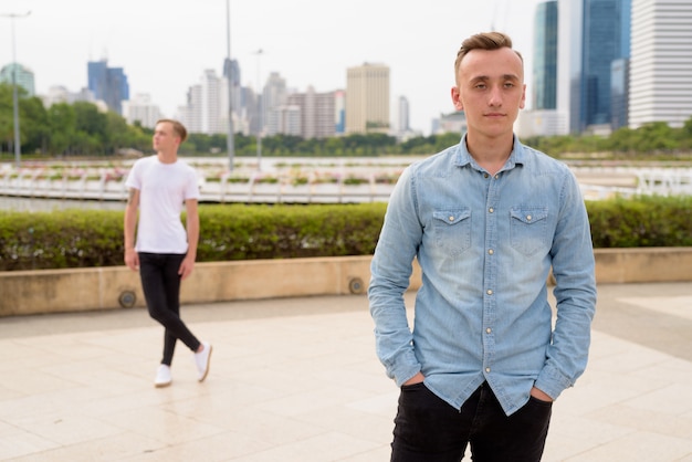 Deux jeunes hommes beaux aux cheveux blonds se détendre dans le parc