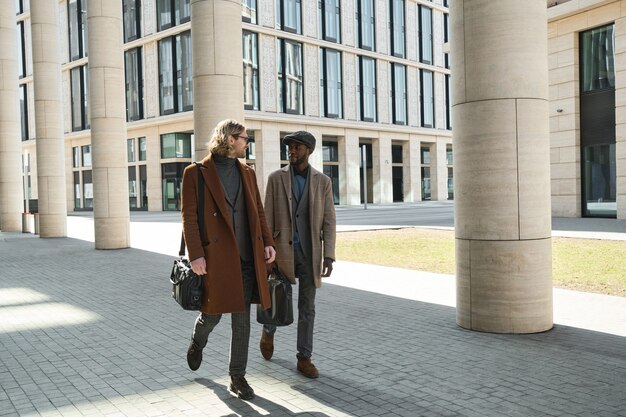 Deux jeunes hommes marchant le long de la rue de la ville en journée ensoleillée