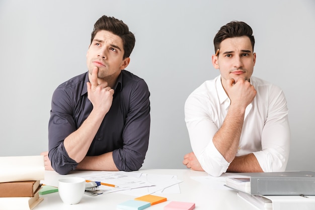 Deux jeunes hommes pensifs assis à la table