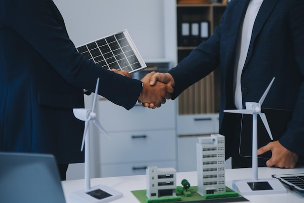 Deux jeunes ingénieurs spécialisés dans l'installation de cellules solaires Réunions et discussions sur le travail Planification de l'installation de panneaux photovoltaïques solaires sur le toit de la salle de bureau avec le plan de construction de l'usine