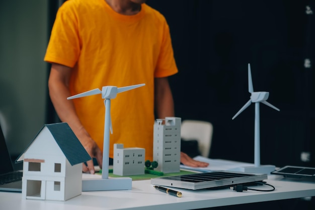 Deux jeunes ingénieurs spécialisés dans l'installation de cellules solaires Réunions et discussions sur le travail Planification de l'installation de panneaux photovoltaïques solaires sur le toit de la salle de bureau avec le plan de construction de l'usine