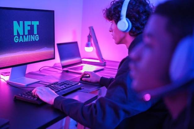Deux jeunes joueurs jouant en ligne depuis chez eux avec des lumières de jeu Concentrez-vous sur les jeunes de l'arrière-plan Jeux vidéo de technologie Concept Gaming