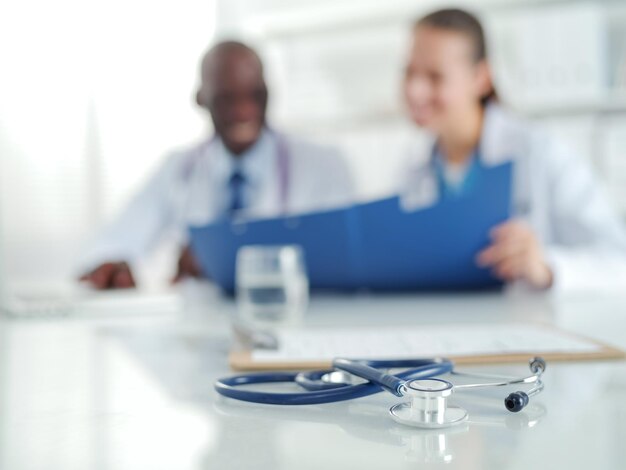 Photo deux jeunes médecins souriants heureux se serrant la main au bureau médecins travail d'équipe