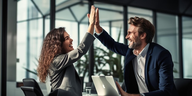 Deux jeunes professionnels célèbrent le travail d'équipe au bureau.