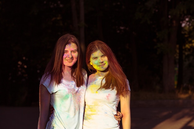 Deux jolies femmes aux cheveux longs recouverts de poudre Gulal colorée