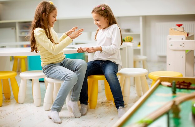 Deux jolies filles meilleures amies ensemble dans la salle de jeux de la pépinière