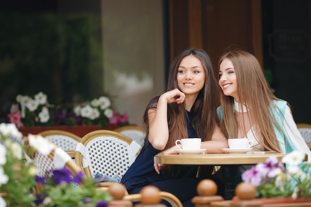 deux jolies jeunes femmes au café avec café et téléphone