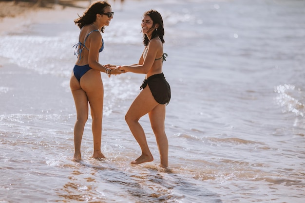 Deux jolies jeunes femmes s'amusant au bord de la mer lors d'une chaude journée d'été