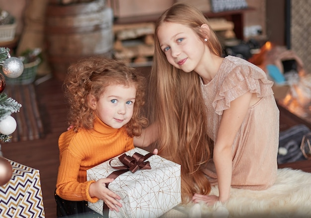 Photo deux jolies sœurs assises par terre la veille de noël.