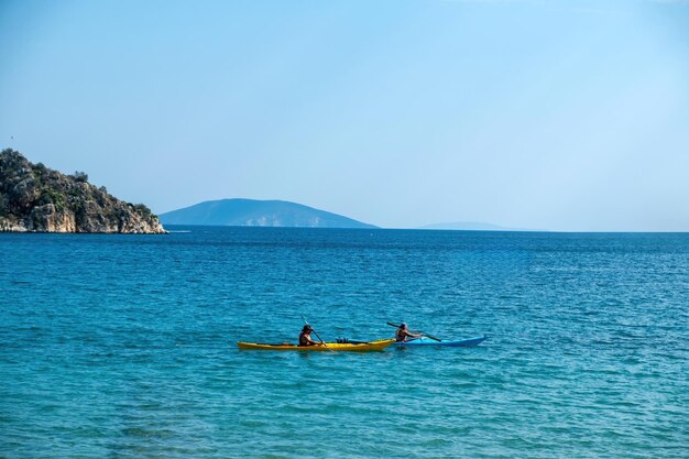 Photo deux kayak en canoë avec rame dans la vaste mer bleue calme grecque fêtes d'été activité sportive amusante et saine