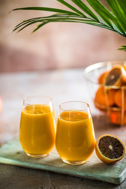 Deux lassi de mangue ou du lait de kesar dans des verres Boisson froide ayurvédique saine indienne à la mangue Fraîcheur lassi faite de yogourt eau épices fruits et glace