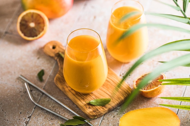 Deux lassi de mangue ou du lait de kesar dans des verres Boisson froide ayurvédique saine indienne à la mangue Fraîcheur lassi faite de yogourt eau épices fruits et glace