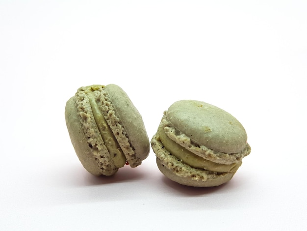 Deux macarons sont assis sur une surface blanche.