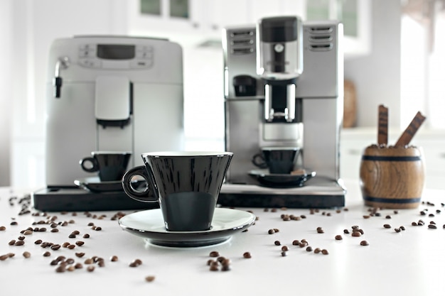 Deux machines à café dans la cuisine à domicile avec un récipient en bois avec des grains de café.