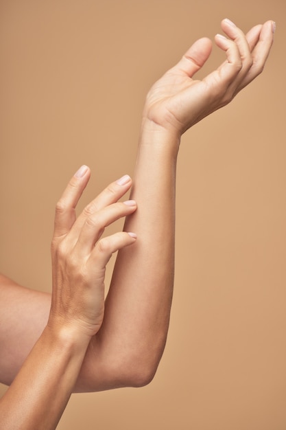 Deux mains féminines élégantes avec manucure nue beauté en studio