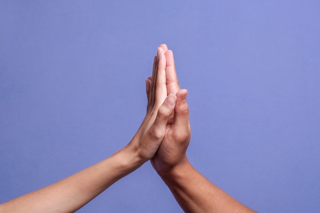 Deux mains de personnes faisant un geste de high five