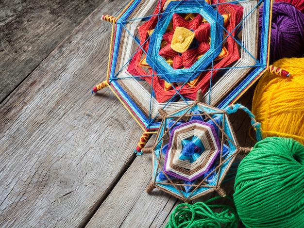 Deux mandalas tibétains tricotés à partir de fils et de fils sur une table rustique