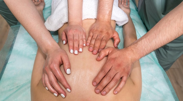 Deux masseuses un homme et une femme donnent un massage complet du corps à une femme