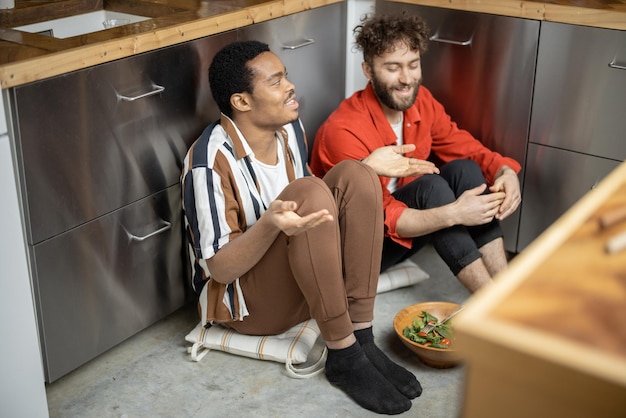 Deux mecs ayant une conversation étroite assis à la cuisine