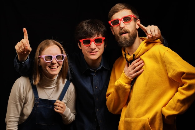 Deux mecs et une fille dans une salle de cinéma regardent un film avec émotion Cinéma Jeunes mecs en lunettes 3D