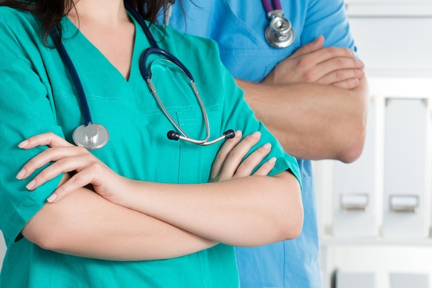 Deux médecins debout, les bras croisés sur la poitrine, prêts à travailler. Concept de soins de santé et médical.