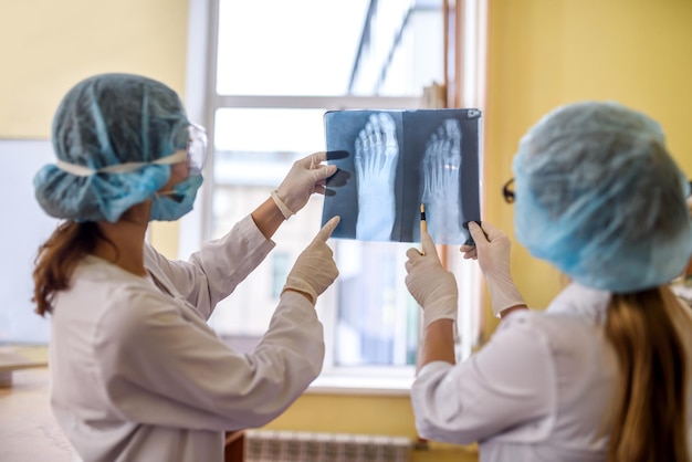 Deux médecins avec radiographie en laboratoire médical posant pour la caméra