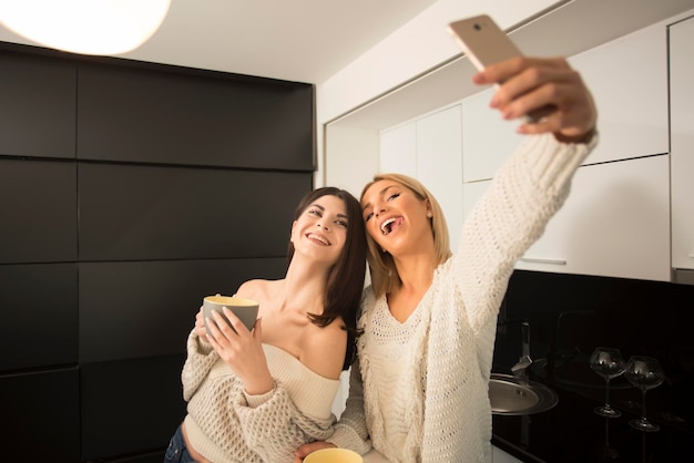 deux meilleures amies buvant du café dans la cuisine. notion d'amis