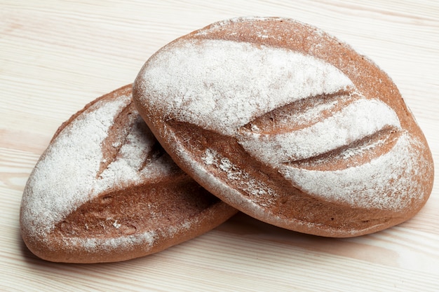 Deux miches de pain sur une planche de bois