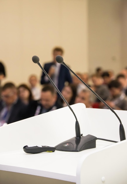 Deux micros à table. Conférence d'affaires. salle pleine de monde