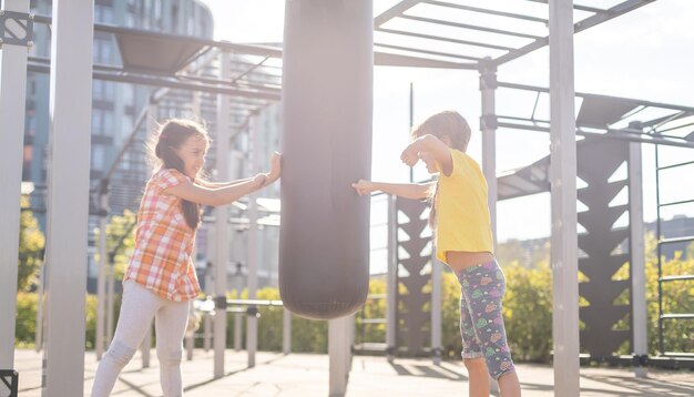 Deux mignonnes petites filles s'amusant sur une aire de jeux à l'extérieur en été. Activités sportives pour les enfants.