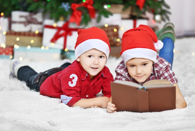 Deux mignons petits frères lisant un livre sur la décoration de Noël