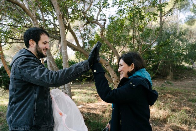 Deux militants célèbrent qu'ils ont défriché la forêt en donnant un high five lors de la collecte des ordures