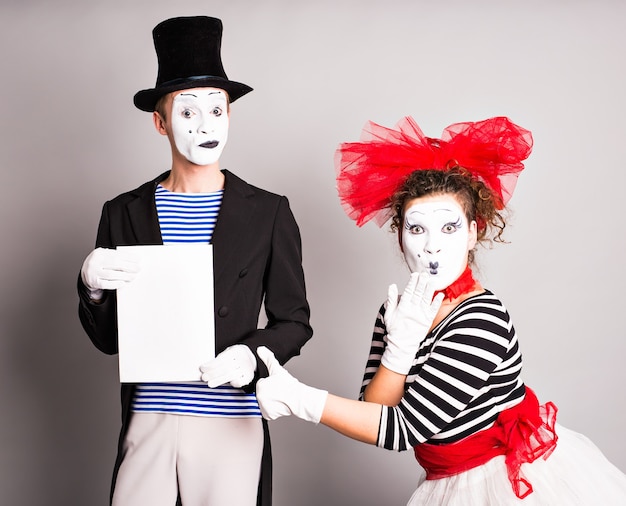 Deux mimes avec un panneau publicitaire, concept du poisson d'avril.